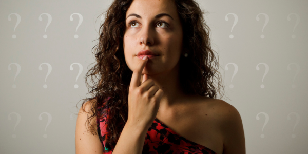 Mulher pensativa com expressão de dúvida, representando questionamentos sobre doação de óvulos e reprodução assistida.